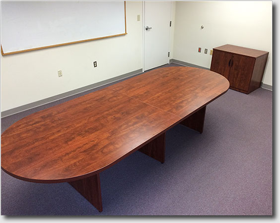 Shows conference table, bureau, whiteboard